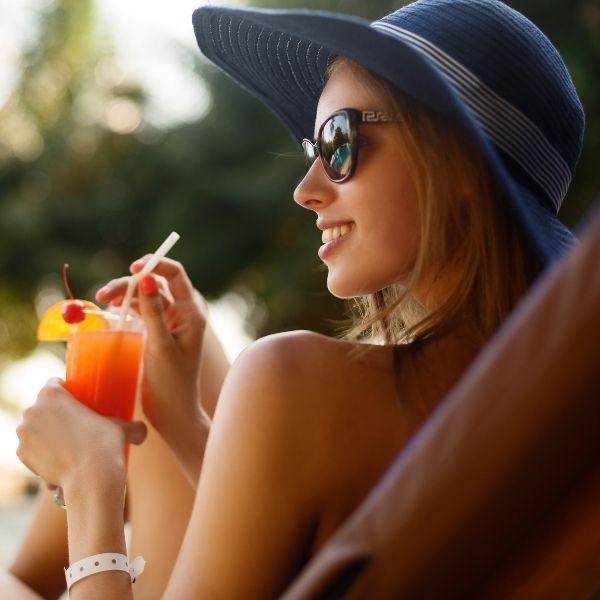 Closeup of a woman enjoying a poolside drink