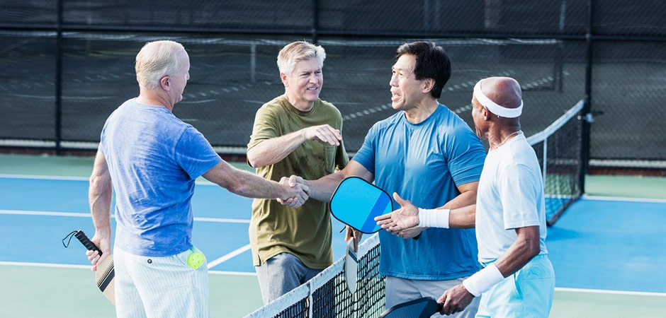 four people playing pickleball