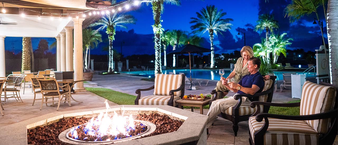 couple by the poolside fire pit at tesoro